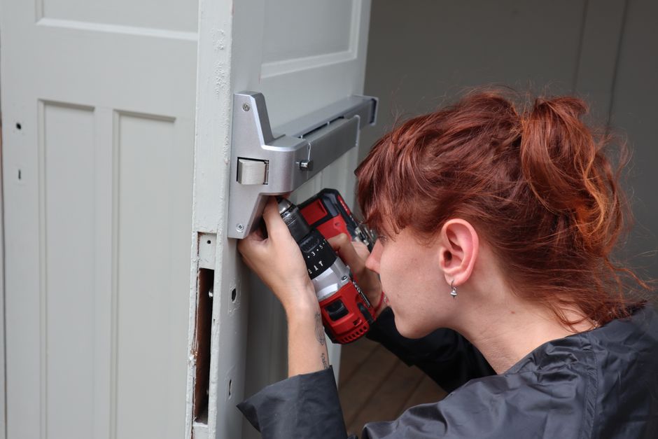 Worker professionally installing a new door